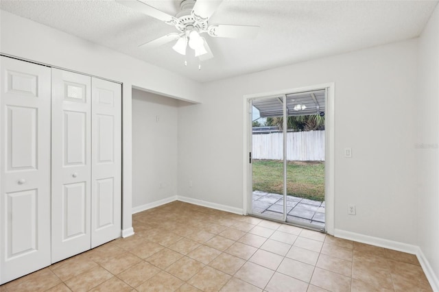 unfurnished bedroom with a textured ceiling, a closet, access to outside, ceiling fan, and light tile patterned floors