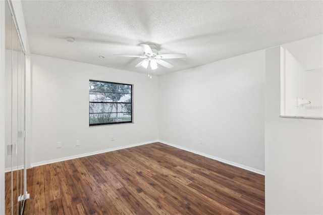 empty room featuring a textured ceiling, ceiling fan, and dark hardwood / wood-style flooring