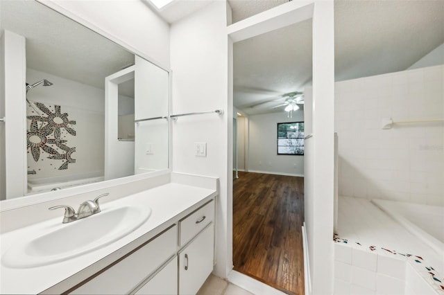 bathroom with ceiling fan, vanity, and separate shower and tub