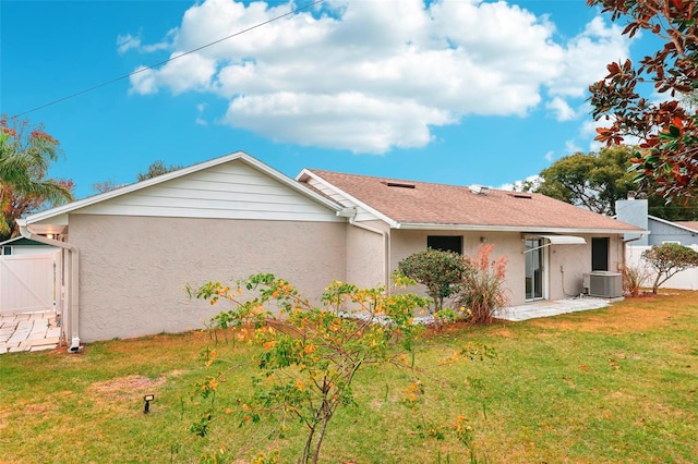 back of house featuring a patio, a lawn, and central AC