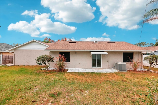 back of property with a patio area, a yard, and central AC