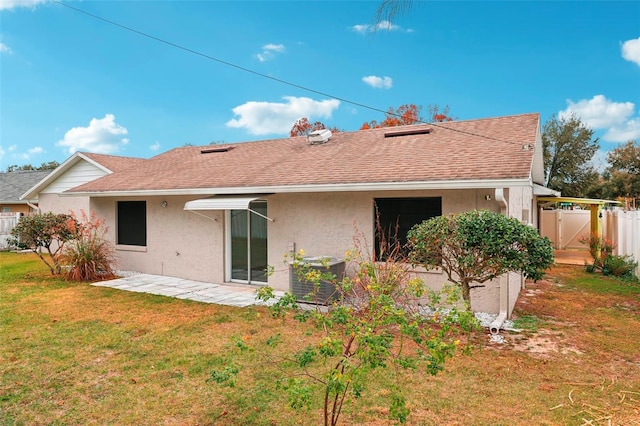 back of house with cooling unit, a yard, and a patio