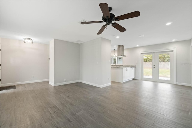 unfurnished living room with ceiling fan, french doors, and hardwood / wood-style floors