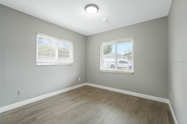 spare room featuring a wealth of natural light and hardwood / wood-style flooring