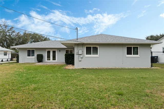 rear view of house featuring a yard and french doors