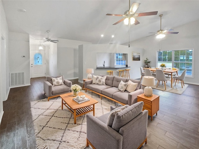 living room with ceiling fan, vaulted ceiling, and light hardwood / wood-style flooring