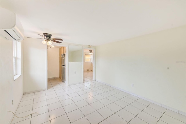 empty room with ceiling fan, a wall mounted AC, and light tile patterned flooring