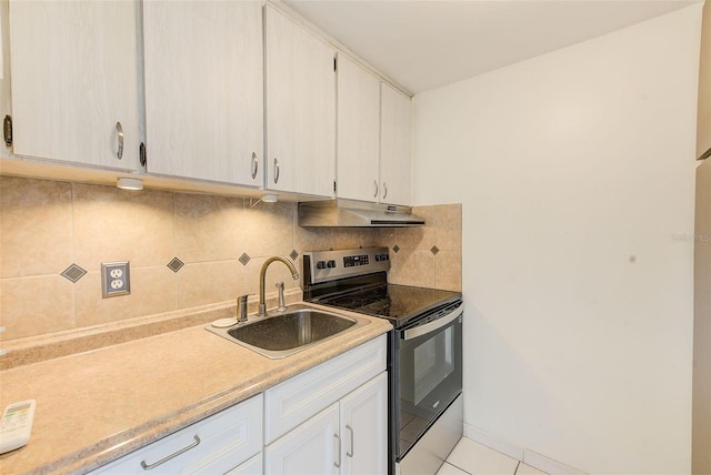 kitchen with tasteful backsplash, light tile patterned flooring, stainless steel electric range, white cabinets, and sink