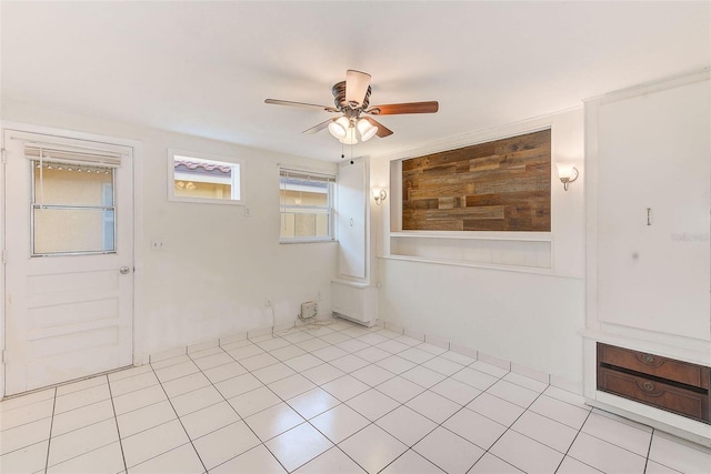 tiled empty room featuring ceiling fan