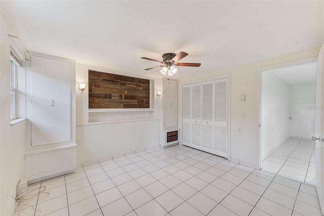 tiled empty room featuring ceiling fan