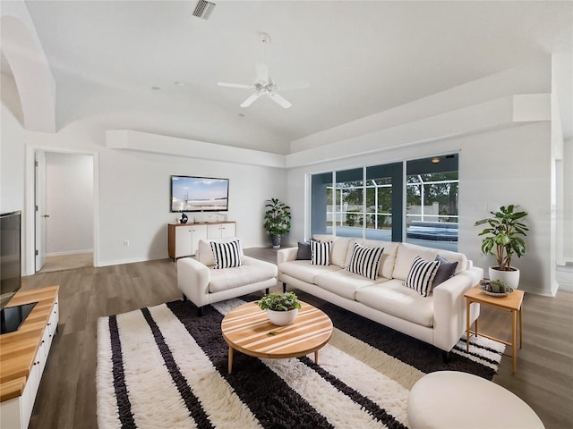 living room featuring ceiling fan, lofted ceiling, and hardwood / wood-style flooring