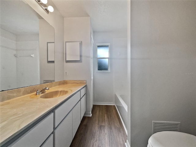 bathroom featuring toilet, wood-type flooring, and vanity