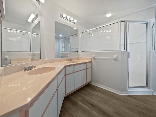 bathroom featuring hardwood / wood-style flooring, a shower with shower door, and vanity