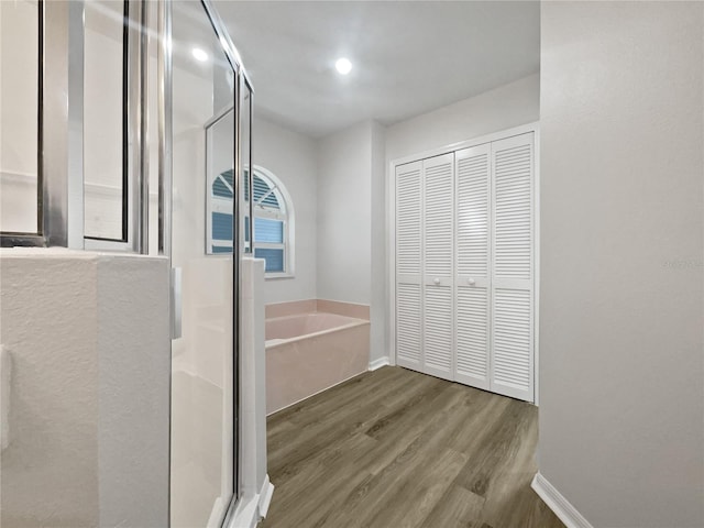 bathroom featuring shower with separate bathtub and hardwood / wood-style floors