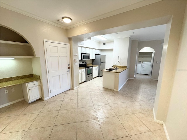 kitchen featuring a sink, crown molding, stainless steel appliances, and washer and dryer