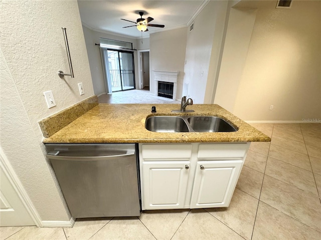 kitchen with crown molding, a glass covered fireplace, dishwasher, and a sink