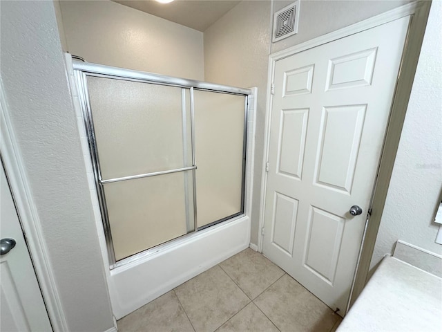 full bath featuring visible vents, bath / shower combo with glass door, and tile patterned floors