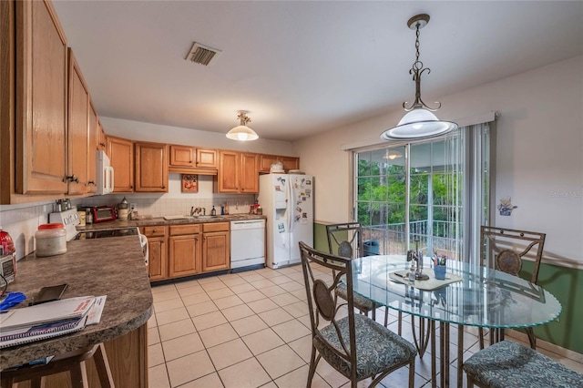 kitchen with white appliances, pendant lighting, light tile patterned floors, backsplash, and sink