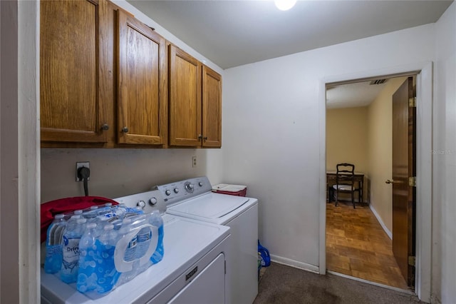 laundry area with washing machine and dryer, cabinets, and dark carpet