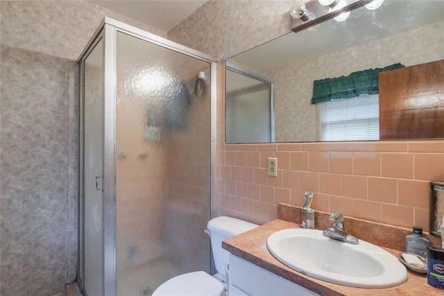 bathroom with toilet, tile walls, backsplash, an enclosed shower, and vanity