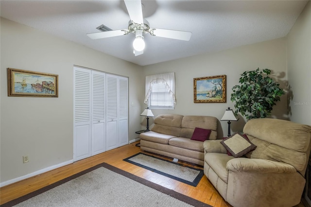 living room featuring ceiling fan and light hardwood / wood-style floors