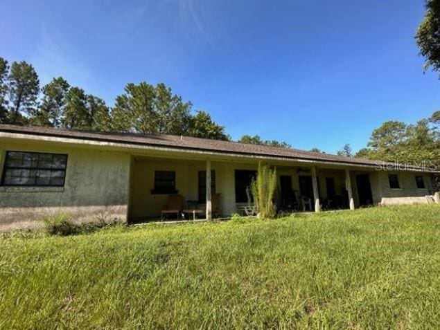 rear view of property with a yard