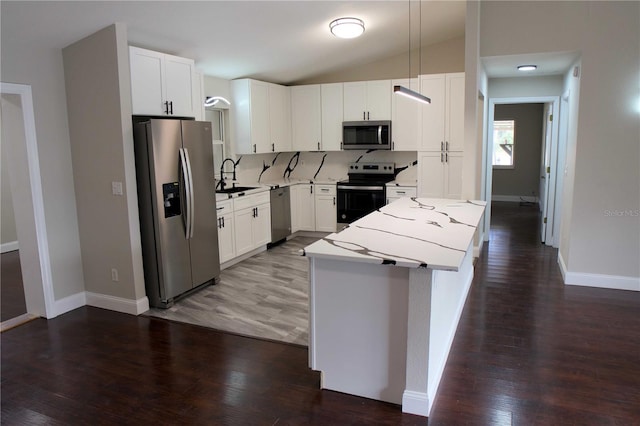 kitchen with light stone countertops, white cabinetry, appliances with stainless steel finishes, and sink