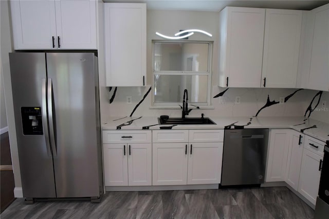 kitchen with backsplash, dark hardwood / wood-style floors, sink, white cabinetry, and appliances with stainless steel finishes