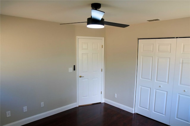 unfurnished bedroom featuring ceiling fan, a closet, and dark hardwood / wood-style floors