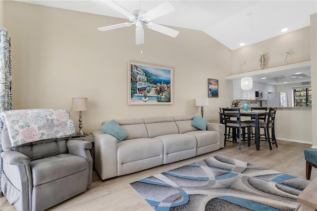 living room featuring vaulted ceiling, ceiling fan, and light hardwood / wood-style floors