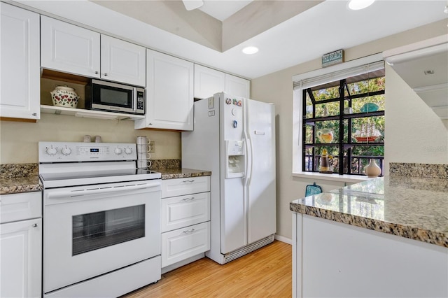 kitchen featuring white appliances, light stone counters, white cabinets, and light hardwood / wood-style flooring