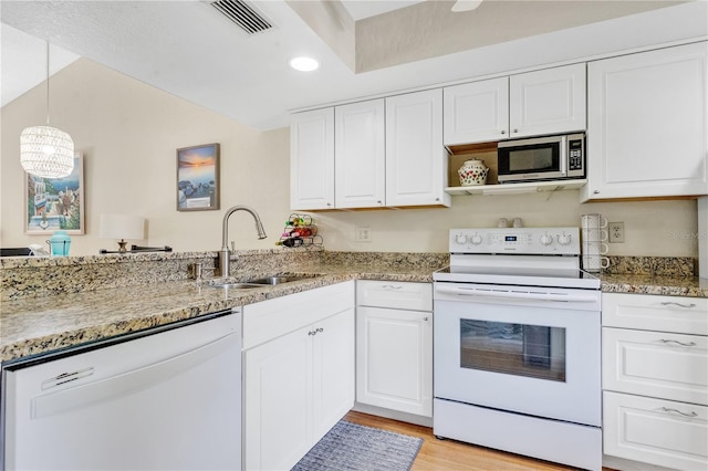 kitchen featuring white appliances, kitchen peninsula, white cabinets, light hardwood / wood-style flooring, and decorative light fixtures