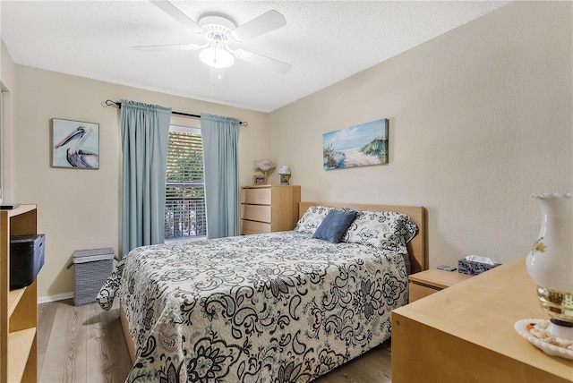 bedroom featuring a textured ceiling, ceiling fan, and hardwood / wood-style floors