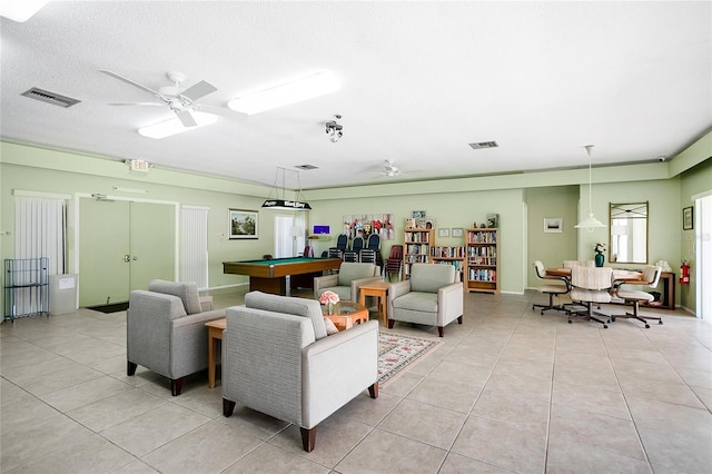 tiled living room featuring ceiling fan, billiards, and a textured ceiling