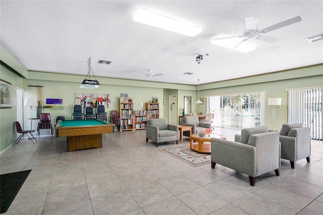 recreation room featuring a textured ceiling, ceiling fan, light tile patterned floors, and billiards