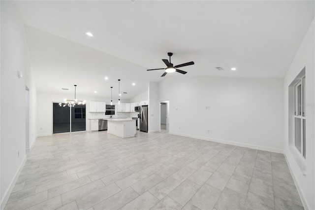 unfurnished living room featuring vaulted ceiling and ceiling fan with notable chandelier