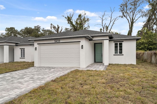 view of front of home with a front lawn and a garage