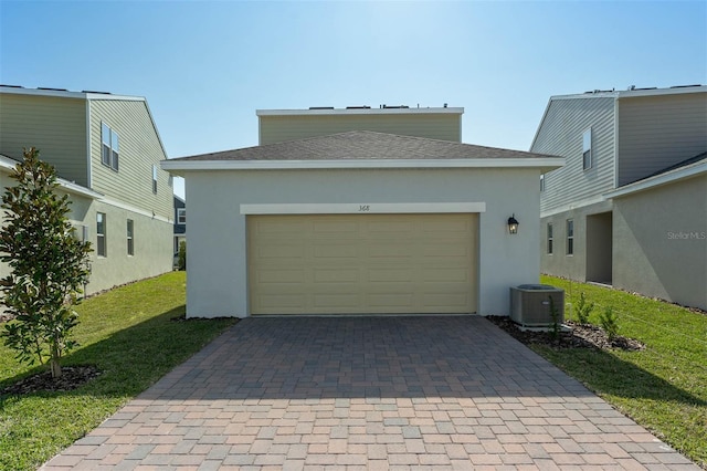 garage featuring a yard and central AC unit