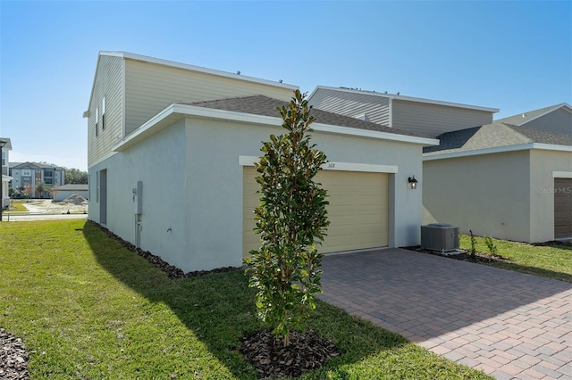 view of property exterior featuring cooling unit, a garage, and a lawn