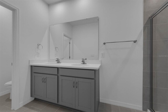 bathroom featuring tile patterned flooring, vanity, walk in shower, and toilet