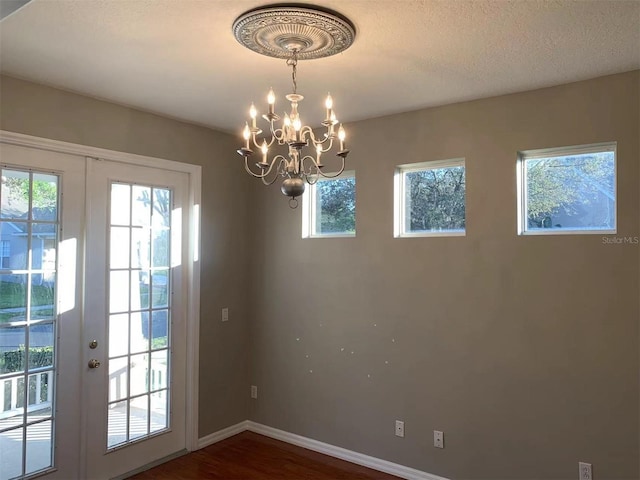 interior space featuring dark wood-type flooring, a chandelier, and french doors