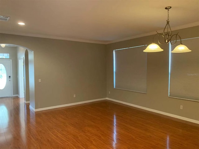 unfurnished dining area with hardwood / wood-style floors, ornamental molding, and a chandelier