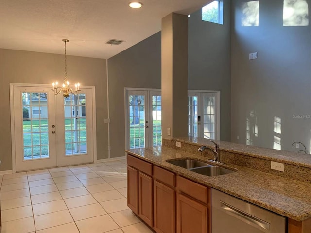 kitchen featuring light stone countertops, light tile patterned flooring, french doors, and sink