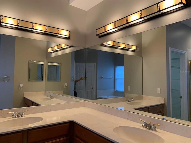 bathroom with a tub to relax in and vanity