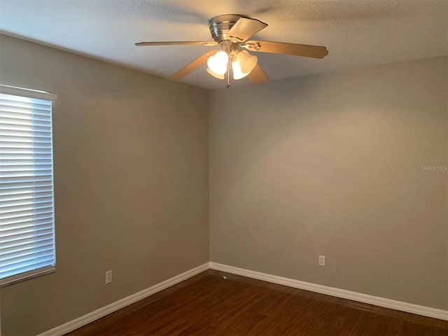 spare room with ceiling fan and dark wood-type flooring