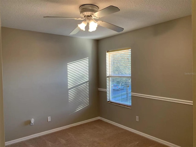 carpeted spare room featuring ceiling fan and a textured ceiling