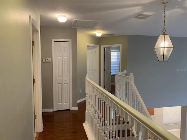 corridor with a textured ceiling and dark hardwood / wood-style floors