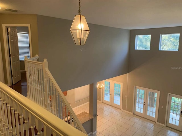 stairway featuring tile patterned floors and french doors