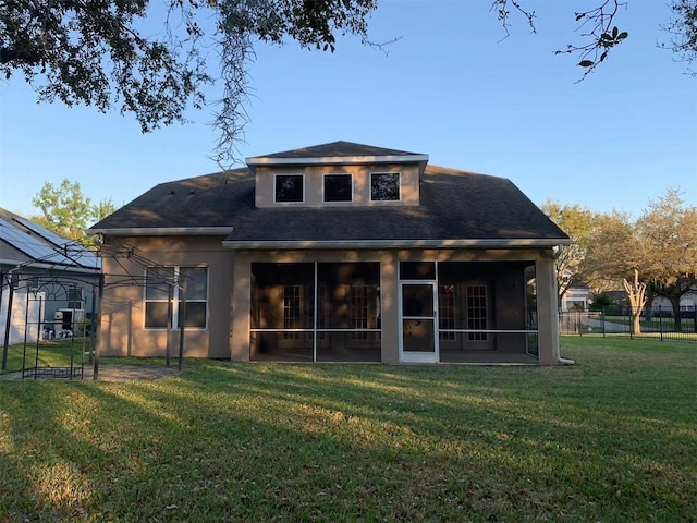 back of house featuring a lawn and a sunroom