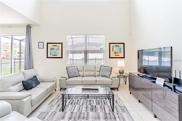 living room with a towering ceiling and light tile patterned floors